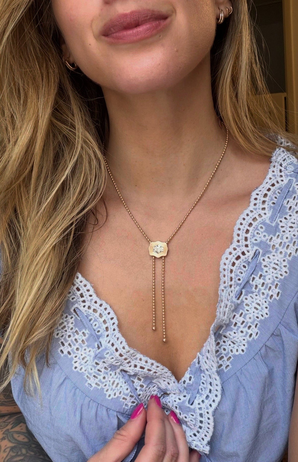 The Elvie Bolo Necklace on a gold bead chain, worn
