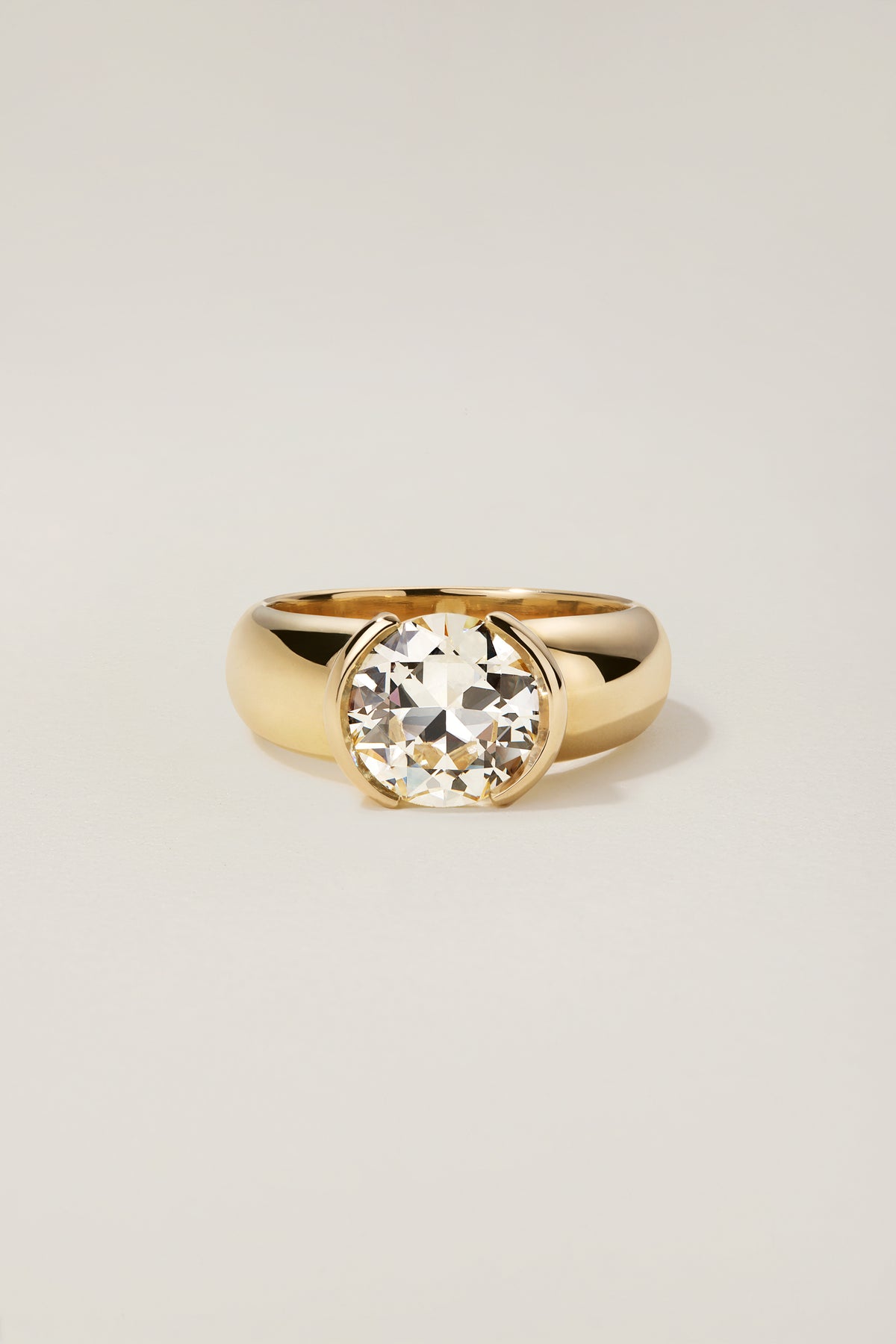 Madeleine Ring, a 2.30 carat old European cut diamond half-bezel set in a wide 18k yellow gold band