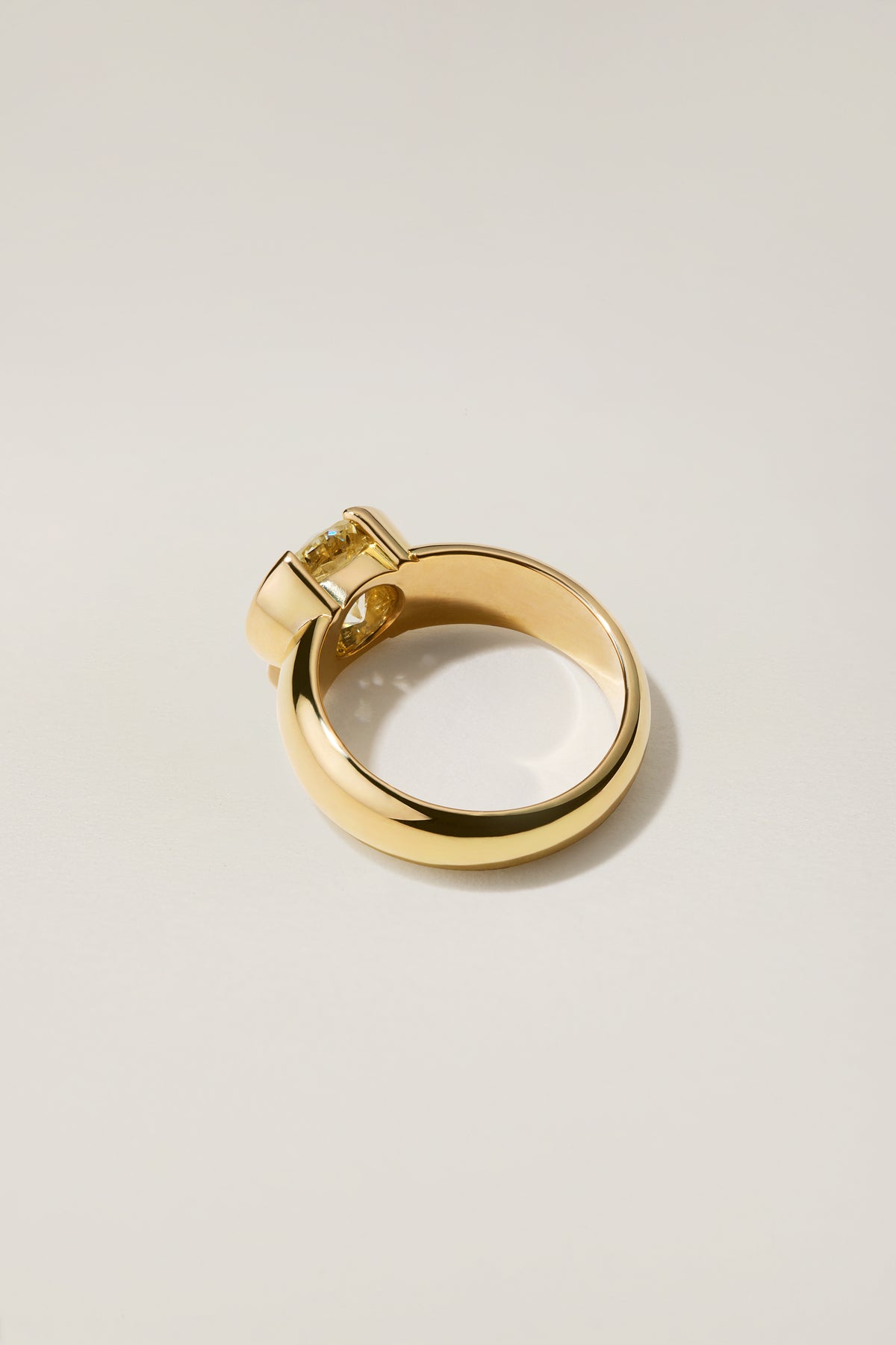 Madeleine Ring in profile, the band nearly as wide as the diamond