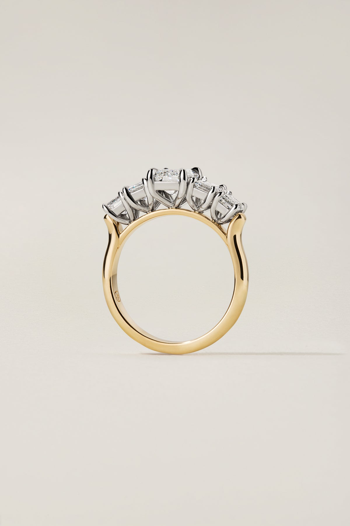 Nicci five-stone ring in profile, showing the open platinum gallery beneath each stone and the 18k yellow gold shank
